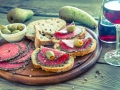 Slices of italian salami with pears and wine